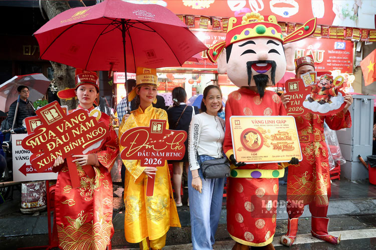 Dù đứng dưới mưa, người dân vẫn giữ tâm trạng phấn khởi, hoan hỉ với hy vọng “rước lộc” vào nhà.