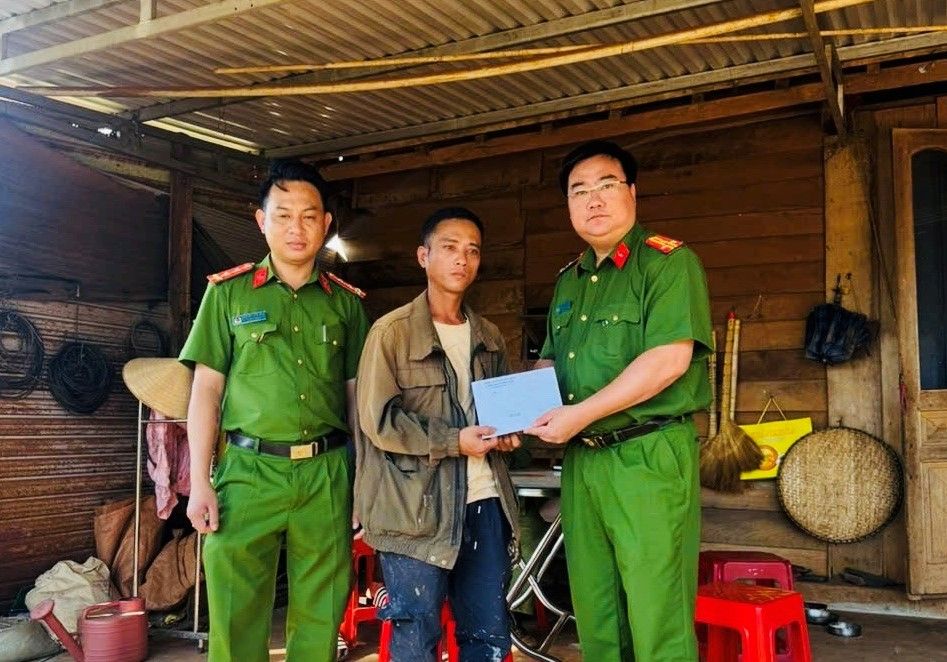 Thượng tá Nguyễn Hồng Tráng – Trưởng Công an xã Đắk Sắk trao hỗ trợ số tiền 10 triệu đồng cho gia đình anh Việt. Ảnh: Công an cung cấp