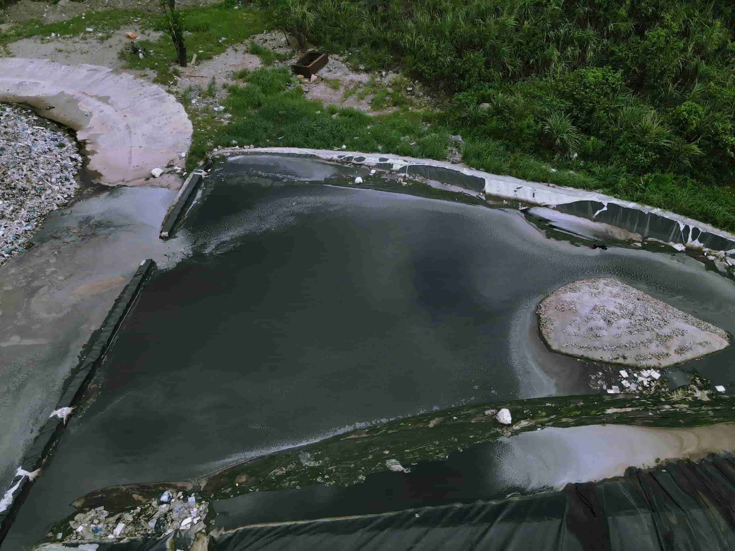 Nước thải từ bãi rác thung Quèn Khó chảy ra khu vực đường nội bộ bốc mùi hôi thối. Ảnh: Nguyễn Trường