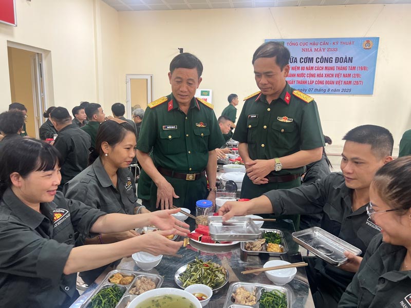 El coronel Nguyễn Văn Đề (izquierda) intercambia opiniones con los miembros del sindicato y los trabajadores de la Fábrica Z133 en el Programa Comida Sindical 2025. Foto: Kiều Vũ