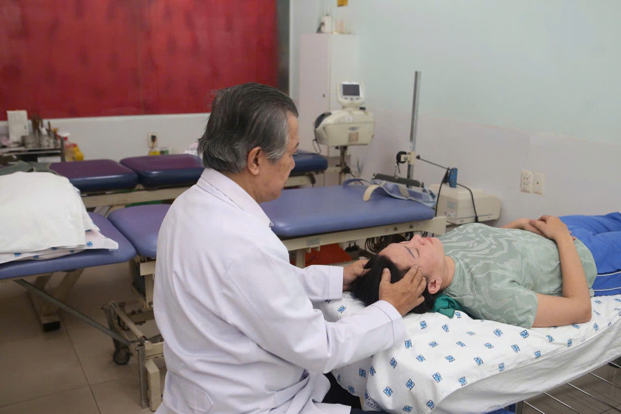 BS.CKII Huỳnh Tấn Vũ tận tuỵ xoa bóp, bấm nguyệt cho bệnh nhân suốt hàng chục năm qua. Ảnh: Nguyễn Ly