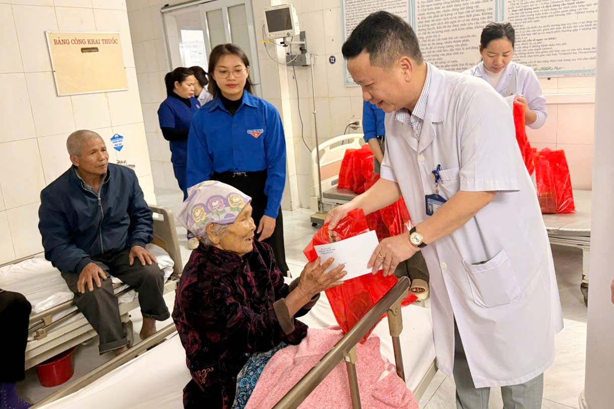 Bác sĩ CK1 Nguyễn Đình Thiện - Giám đốc Trung tâm Y tế Đức Thọ tặng quà cho bệnh nhân. Ảnh: Trần Tuấn