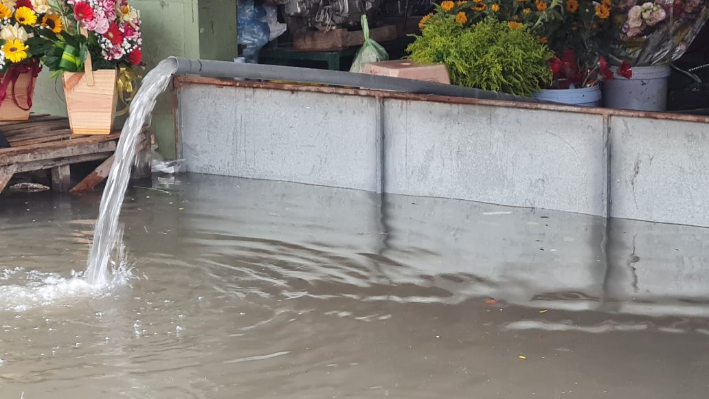 Nước tràn vào nhà, người dân dùng máy bơm nước ra ngoài tại đường Trần Phú, Phường Bạc Liêu. Ảnh: Nhật Hồ.