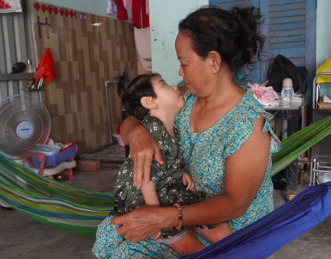 Ms. Nguyen Thi Quynh Hoa - baby Le Khanh Han's grandmother, takes care of her grandchild's daily meals and sleep when she has epilepsy, brain atrophy and has been bedridden for 3 years. Photo: Phuong Anh