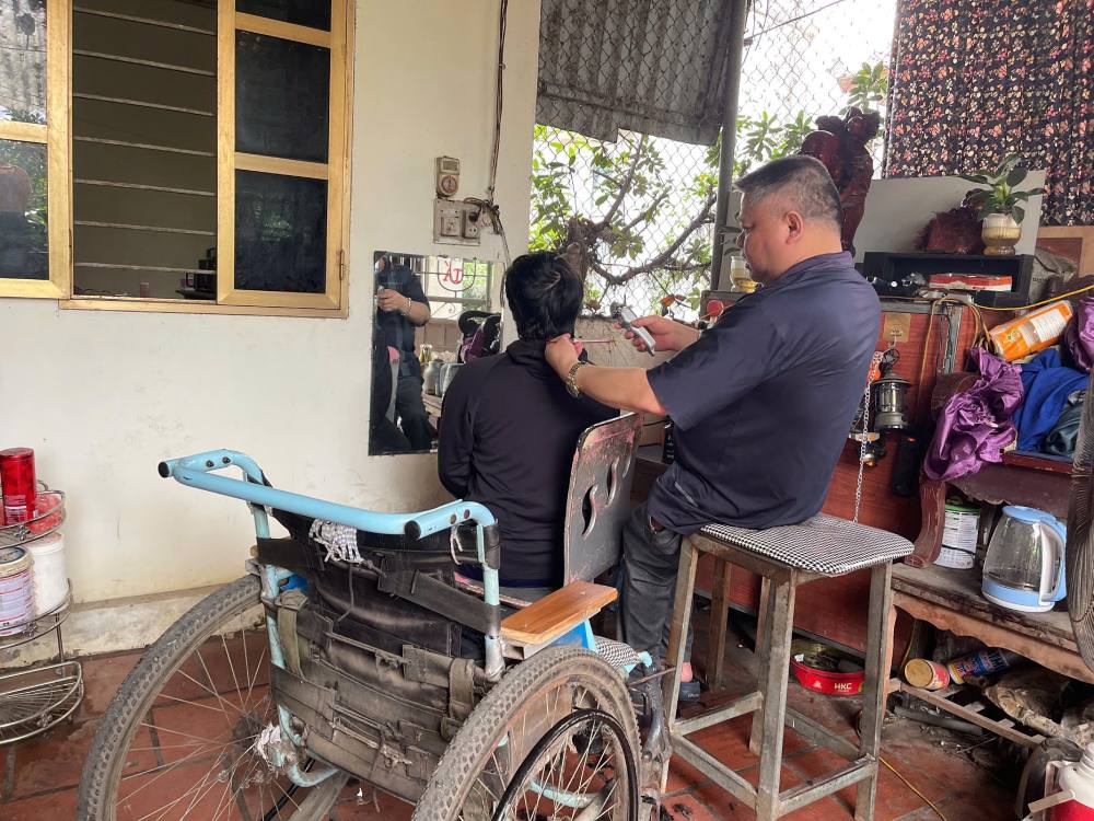 Burdened with worrying about his wife and children, even though he is sick, Mr. Ta still tries to work as a hairdresser. Photo: Quynh Chi