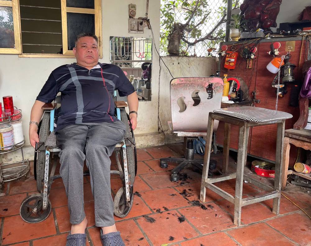 Để có tiền nuôi gia đình, ông Tá làm nghề cắt tóc... Ảnh: Quỳnh Chi