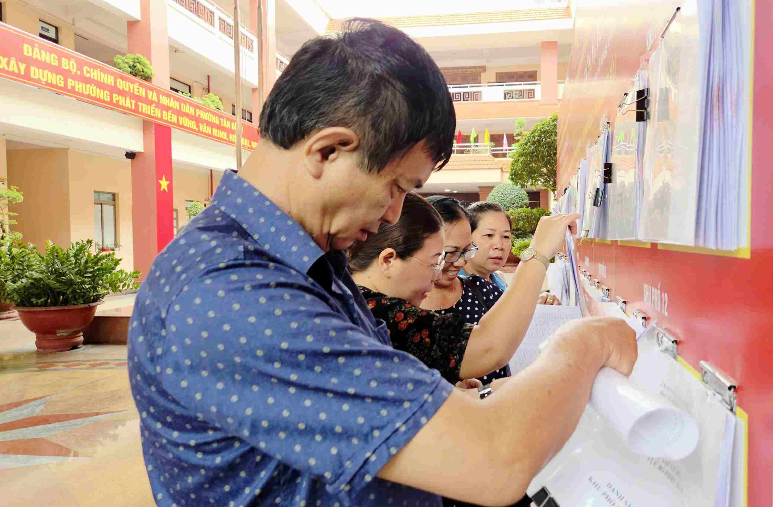 Người dân xem danh sách cử tri. Ảnh: Minh Tâm