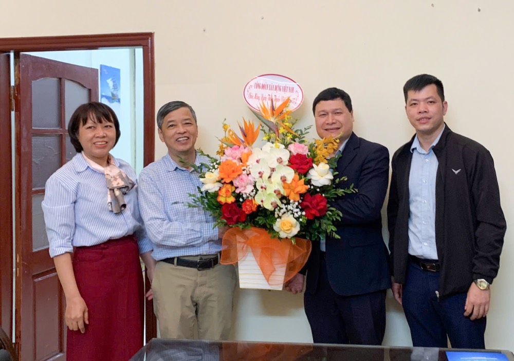 Đồng chí Nguyễn Thanh Tùng, Phó Chủ tịch Công đoàn Xây dựng Việt Nam (thứ 2 từ phải sang) tặng hoa chúc mừng Trung tâm Bảo vệ sức khỏe lao động và Môi trường Giao thông vận tải. Ảnh: CĐXDVN