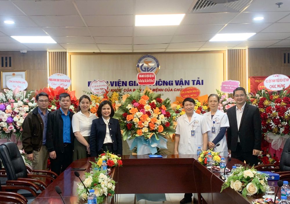 Đồng chí Âu Thị Định, Phó Chủ tịch Công đoàn Xây dựng Việt Nam (thứ 4 từ trái sang) tặng hoa chúc mừng Bệnh viện Giao thông vận tải. Ảnh: CĐXDVN