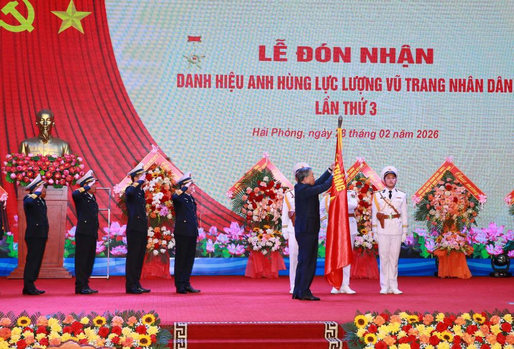 General Secretary To Lam affixes the Hero of the People's Armed Forces badge to the Determined to Win Military Flag. Photo: Navy Command