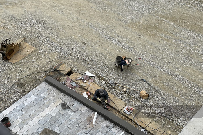 Công nhân hoàn thiện hạng mục nhỏ phía ngoài bệnh viện. Ảnh: Đinh Đại