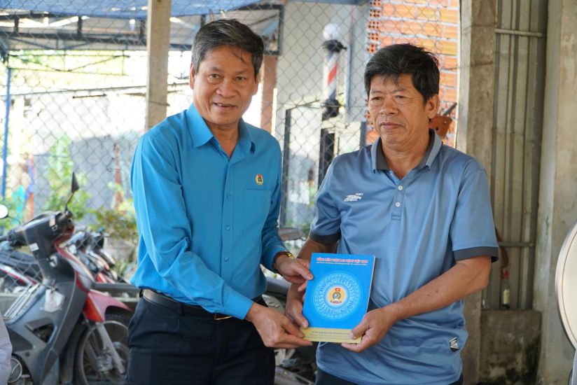 Phó Chủ tịch Tổng LĐLĐVN Huỳnh Thanh Xuân trao tiền hỗ trợ gia đình đoàn viên Lê Bá Hiếu, ở xã Sơn Tịnh bị nước lũ cuốn trôi trên đường đi làm về. Ảnh: VIÊN NGUYỄN