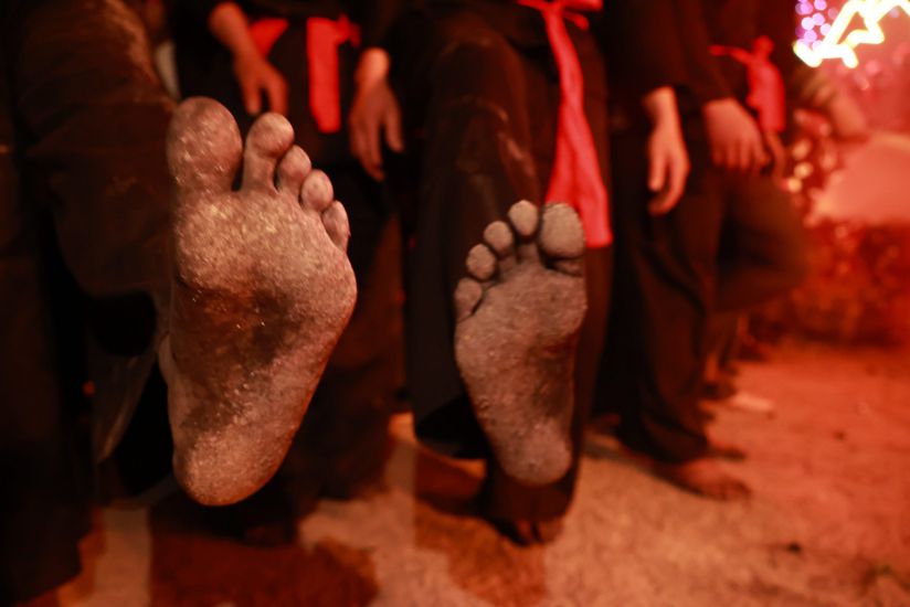 Đôi chân trần vục sâu trong đống than đỏ cho đến khi than tàn hẳn mới thôi. Đây là biểu hiện sức mạnh, sự gan dạ, lòng dũng cảm, khéo léo, nhanh nhẹn của người đàn ông Dao đỏ. Ảnh: DUY DŨNG