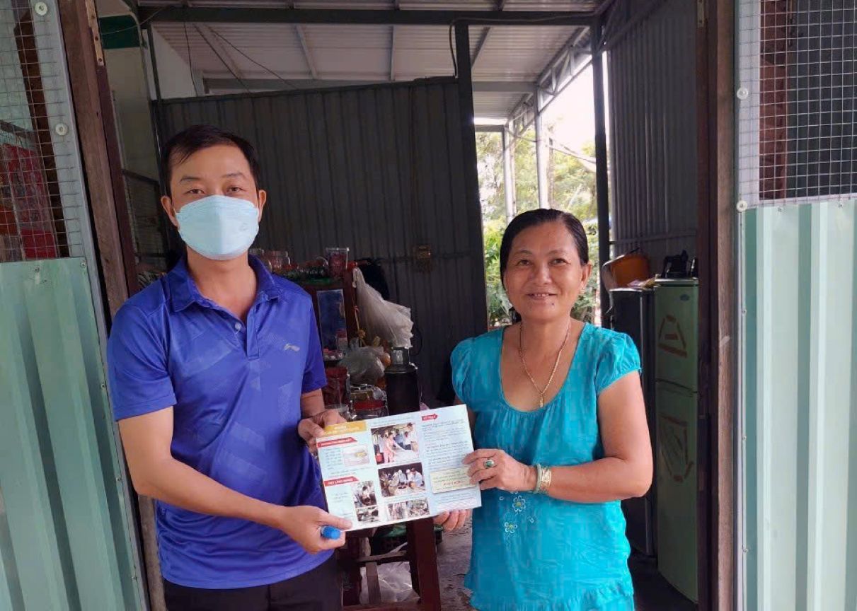 Trao tài liệu hỗ trợ kiến thức dự phòng cho người dân. Ảnh: NVCC