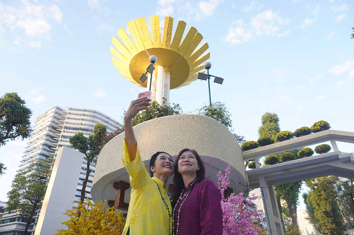 Turtle Lake is brilliantly colored with spring colors, attracting people to take Ao Dai photos. Photo: Nhu Quynh