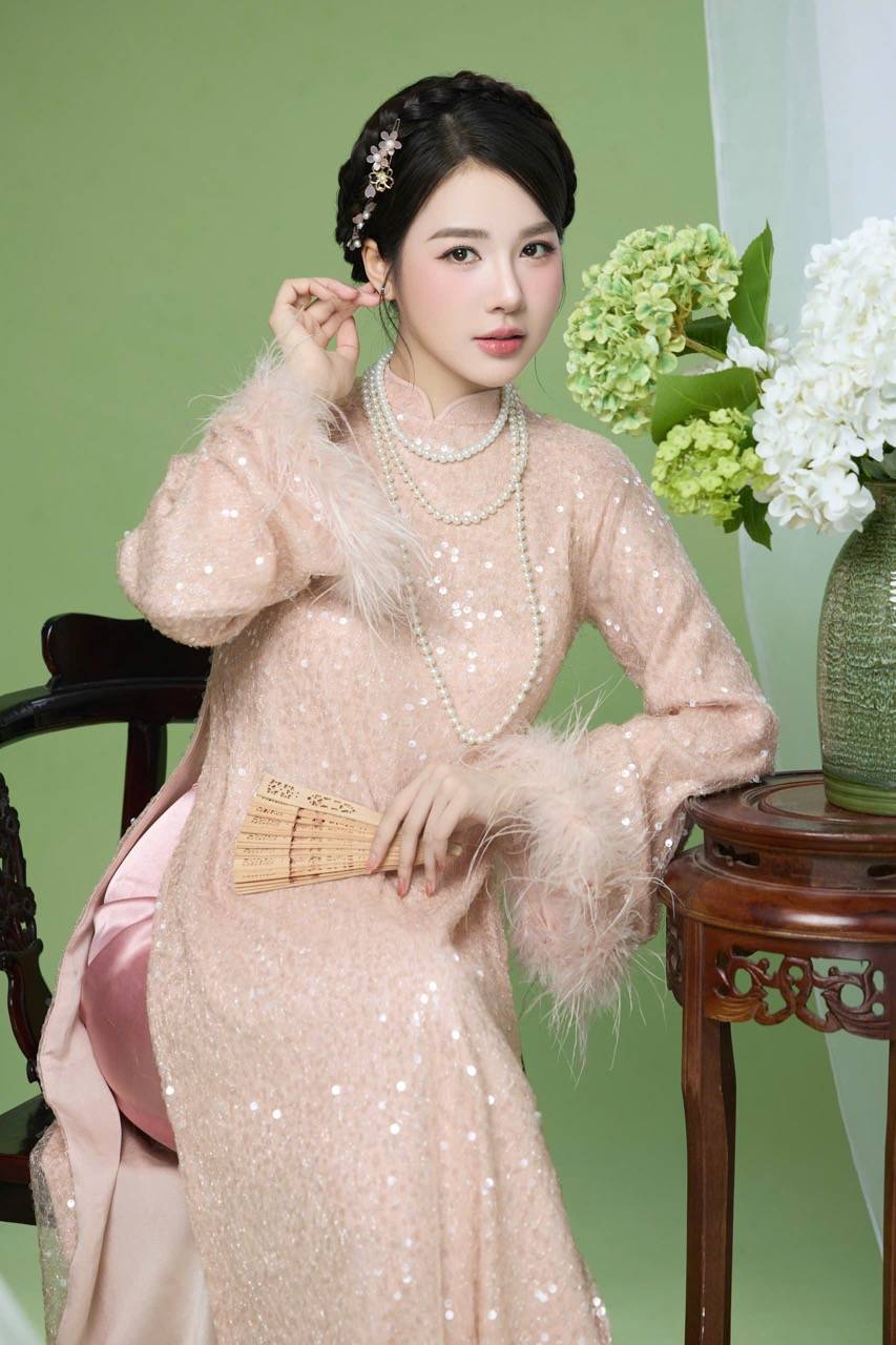 Phần tay áo đính lông vũ mỏng tạo cảm giác bồng bềnh, uyển chuyển theo từng chuyển động, mang lại tổng thể vừa sang trọng vừa nhẹ nhàng như không khí đầu xuân. 