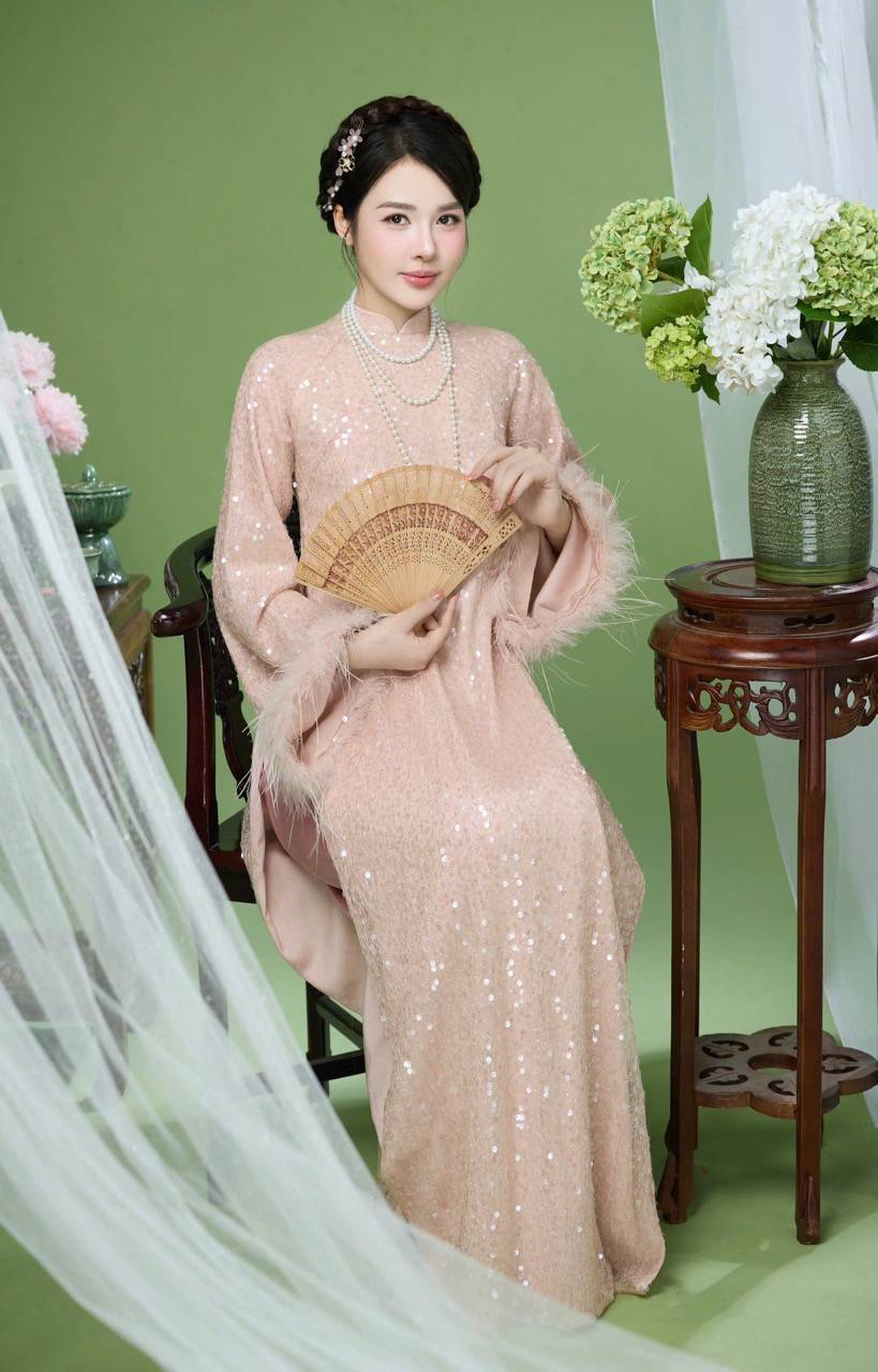  Phụ kiện đi kèm như chuỗi ngọc trai nhiều lớp, quạt gỗ truyền thống được phối hợp tinh tế, góp phần hoàn thiện hình ảnh thiếu nữ ngày Tết mang vẻ đẹp cổ điển. Lối trang điểm trong veo, làn da mịn màng và ánh mắt dịu dàng khiến khung hình thêm phần tinh khôi, đúng tinh thần “xuân về an yên”.  