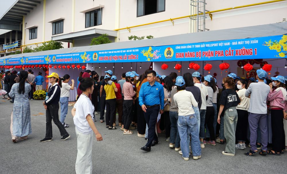 Công nhân lao động hứng khởi tham gia cổ vũ thi gói bánh chưng. Ảnh: Quách Du