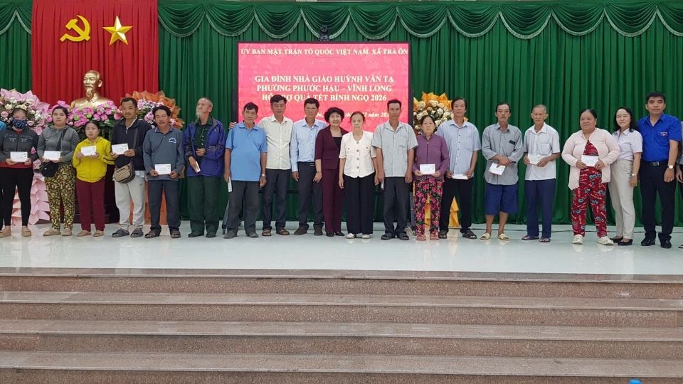 Representatives of teacher Huynh Van Ta's family and Vinh Long Provincial Association for Promoting Education present Tet gifts to poor households and studious students in the province. Photo: Hoang Loc