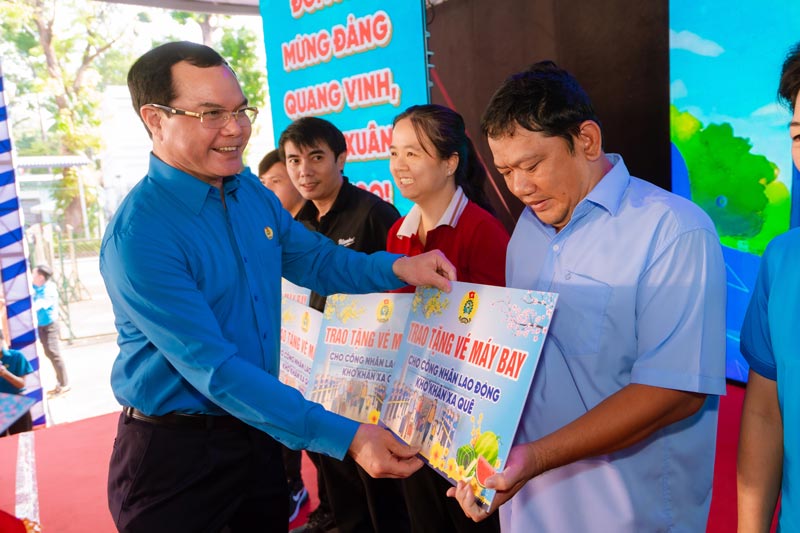 Mr. Nguyen Dinh Khang - Member of the Party Central Committee, Vice Chairman of the Central Committee of the Vietnam Fatherland Front, President of the Vietnam General Confederation of Labor - presents air tickets to workers in difficult circumstances, far from home at the Binh Ngo Spring Trade Union Tet Market Program 2026. Photo: Vietnam General Confederation of Labor