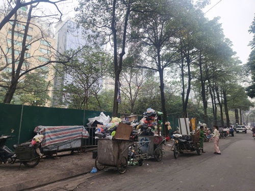 Tại Hà Nội, nhiều điểm tập kết xe rác chiếm lòng đường. Ảnh: Đặng Tiến