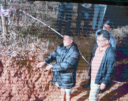 Phạm Thành Tài est emmené sur les lieux de l'enfouissement de la moto lors du vol de banque. Photo: Thanh Tuấn