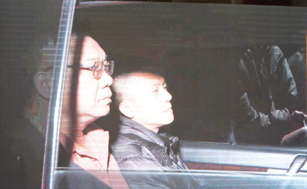 은행 강도 사건을 조사하고 재현하기 위해 현장으로 호송되는 기능 부대의 차량에 탑승한 Tài đen (오른쪽). 사진: Thanh Tuấn