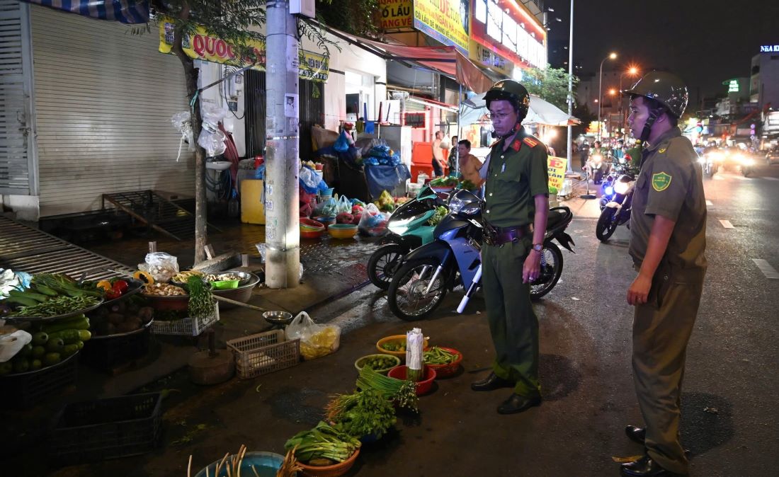 Lực lượng chức năng nhắc nhở, kiểm tra người dân buôn bán trên vỉa hè. Ảnh: PC08
