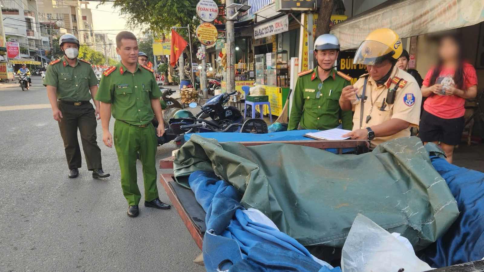 Traffic police and Tan Son Ward Police (HCMC) make a record to handle a case of road encroachment. Photo: Minh Tam