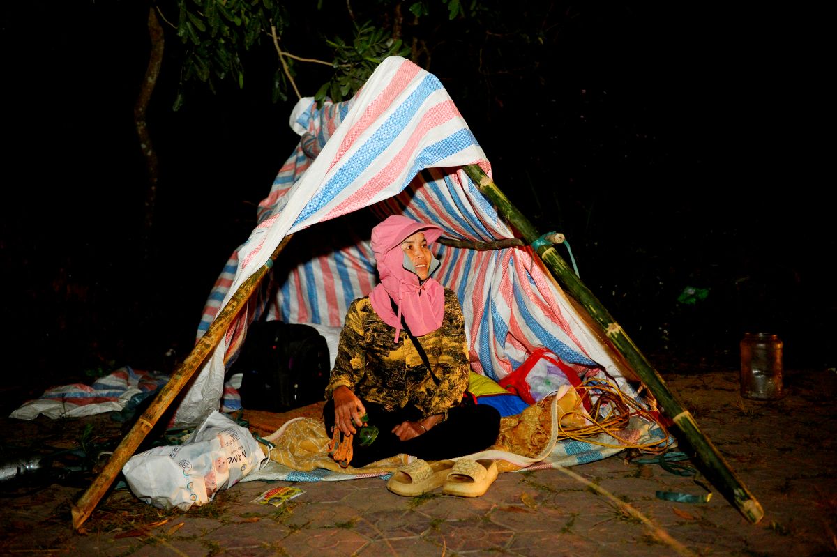 Bà Lê Thị Hường (trú tại xã Xuân Du, tỉnh Thanh Hóa) dựng lều, xuyên đêm canh đào trên đường Trịnh Kiểm. Ảnh: Quách Du