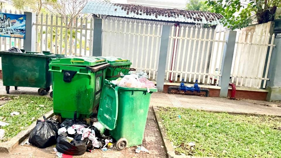 Rác sinh hoạt để lộ trong ban ngày tại điểm tập kết tạm thời, ảnh hưởng mỹ quan đô thị. Ảnh: Hoàng Lộc