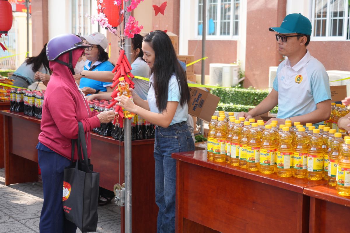 Trao những mặt hàng 0 đồng cho các hoàn cảnh khó khăn trong phiên chợ. Ảnh: Thành An