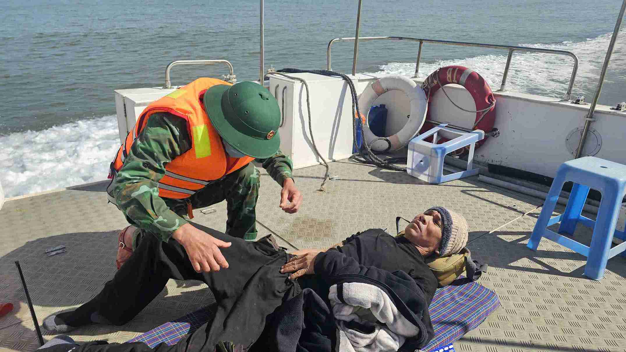 Cán bộ, chiến sĩ Biên phòng hỗ trợ y tế khẩn cấp cho ngư dân bị thương.