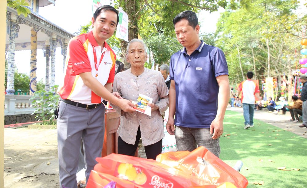 Ngoài việc nhận 40 phần quà thiết yếu, mỗi người dân đến chợ đều được lì xì 300 nghìn đồng. Số tiền mặt này do các doanh nghiệp, đơn vị hỗ trợ. Ảnh: Hưng Thơ