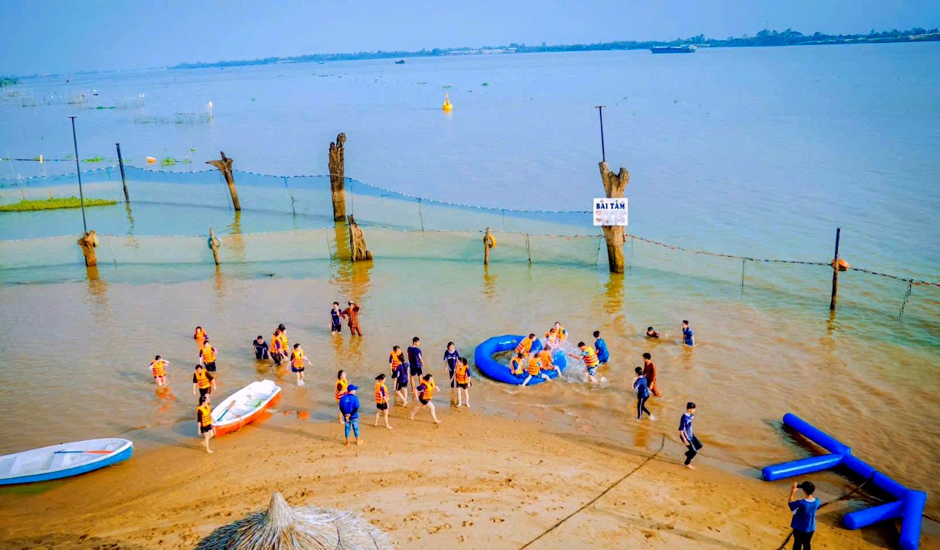 Bãi cát thoai thoải ven sông Tiền, mang lại cho du khách cảm giác mênh mang như tắm biển. Ảnh: Kim Yến