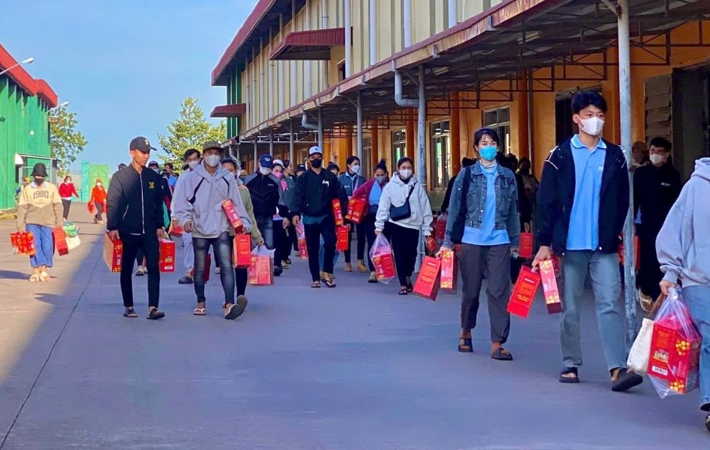 Công nhân mang quà Tết về sau khi tan ca. Ảnh: Phạm Duy 