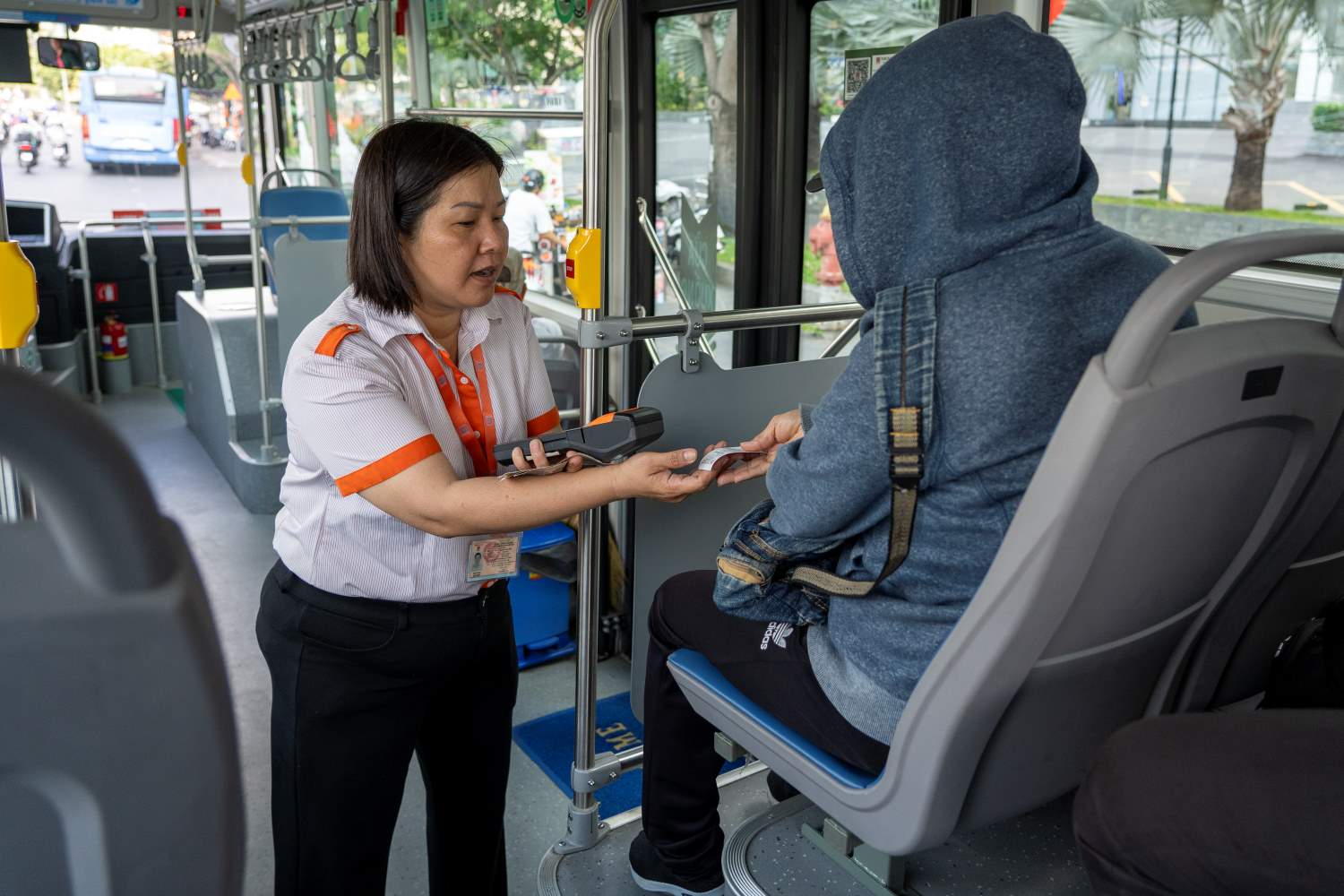 Passengers buy tickets to take electric buses in Ho Chi Minh City. Photo: Minh Quan