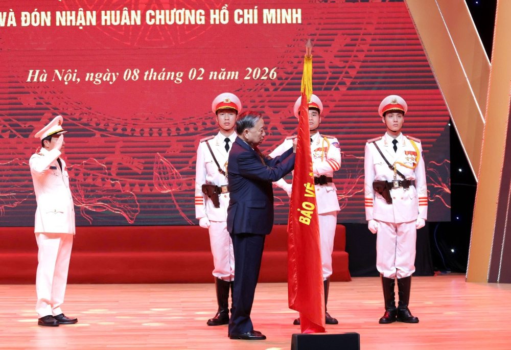 Tổng Bí thư Tô Lâm gắn Huân chương Hồ Chí Minh lên Lá cờ truyền thống của lực lượng Tình báo Công an nhân dân. Ảnh: Bộ Công an 