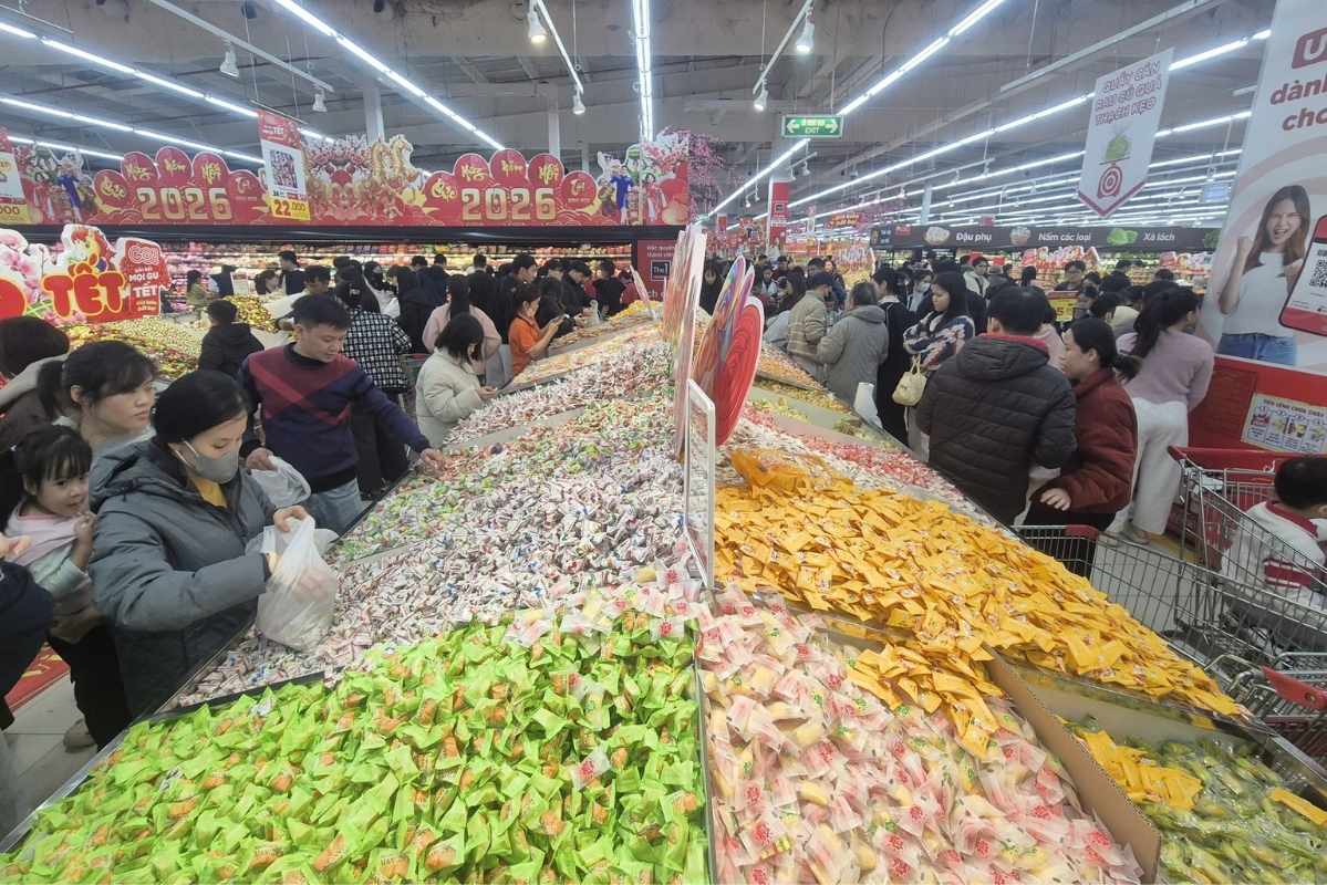 Quầy kẹo Tết thu hút lượng lớn khách hàng, ai cũng cầm trên tay một túi nilon sẵn sàng lựa chọn. Ảnh: Phan Anh 