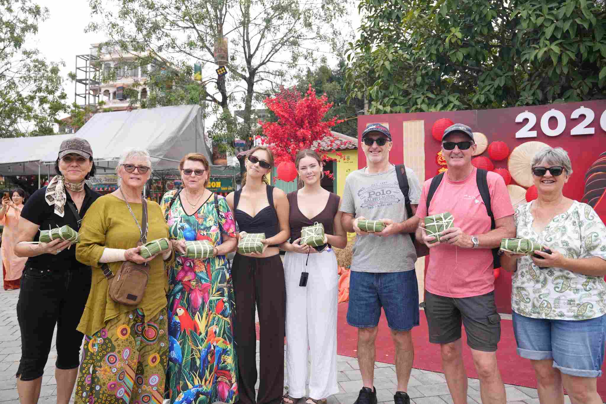 Foreign tourists are excited to experience wrapping banh chung at Tam Coc - Bich Dong tourist area. Photo: Dieu Anh