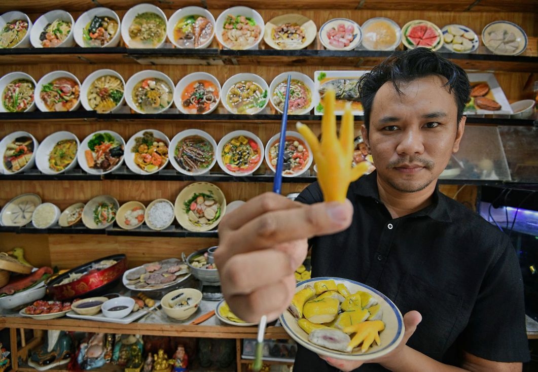 Nghệ nhân, họa sĩ Nguyễn Tấn Đạt với những tác phẩm - sản phẩm làm bằng tay, sống động có giá trị thiết thực. Ảnh: Việt Văn