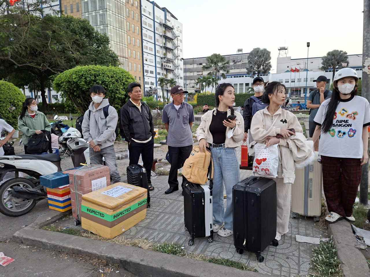 Người dân ngồi, đứng vạ vật bên Quốc lộ 1, đoạn trước Khu chế xuất Linh Trung chờ đón xe “dù”.  Ảnh: Minh Quân