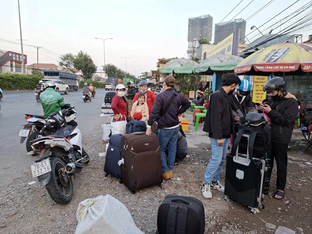 Người dân chờ đón xe trên Quốc lộ 1 đoạn trước bến xe Lam Hồng.  Ảnh: Minh Quân