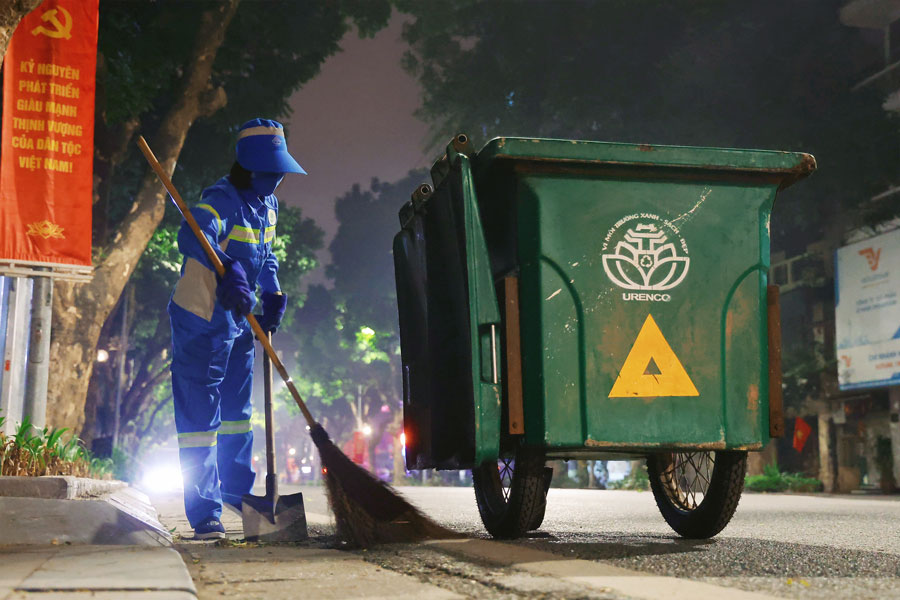 Accompanying environmental workers, on duty throughout Tet to keep streets clean and beautiful