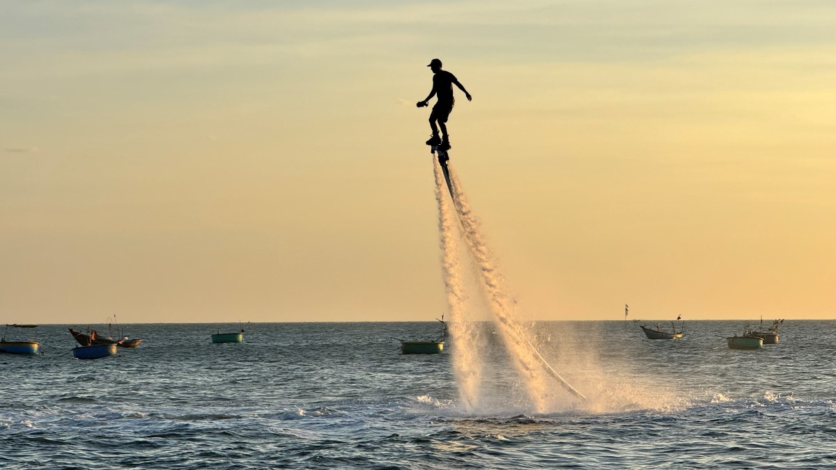 Lực đẩy của nước biển nâng người trình diễn flyboard đứng trên không trung. Ảnh: Duy Tuấn 