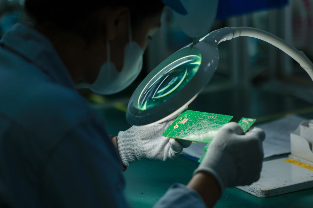 hân viên kỹ thuật kiểm tra bảng mạch điện tử tại Công ty TNHH Rhythm Việt Nam (Hà Nội). Ảnh: Hải Nguyễn
