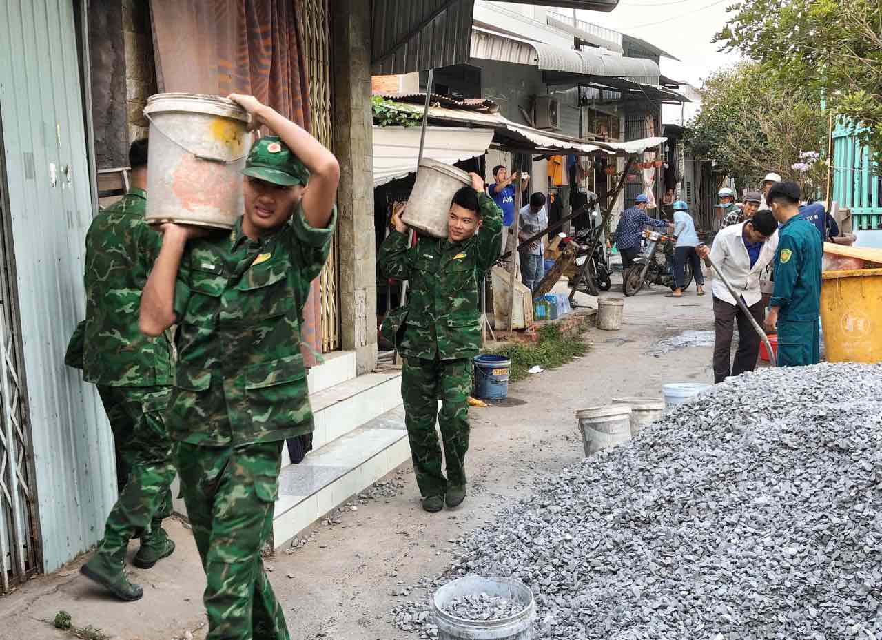 Cán bộ, chiến sĩ Đồn Biên phòng cùng người dân chung tay làm đường giao thông nông thôn. Ảnh: Huỳnh Hoà