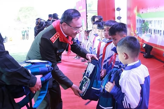 Thượng tướng Phạm Thế Tùng trao đồ dùng học tập cho các em học sinh. Ảnh: Ngọc Anh