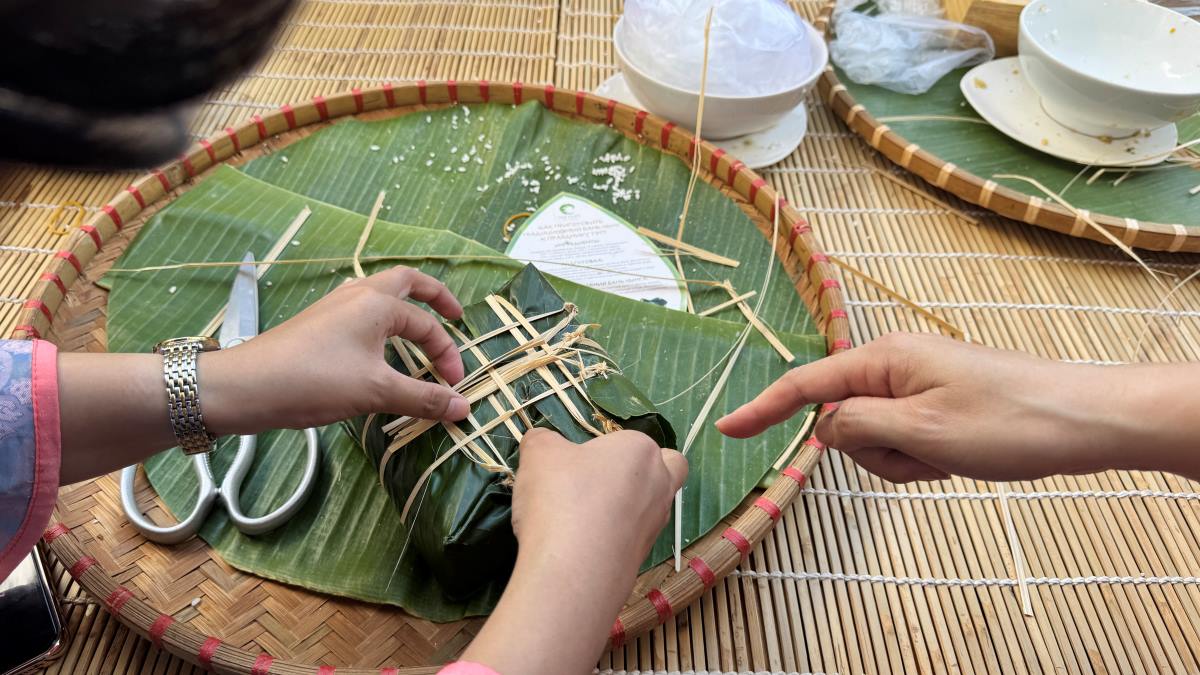 Tourists wrapping banh chung in Mui Ne.