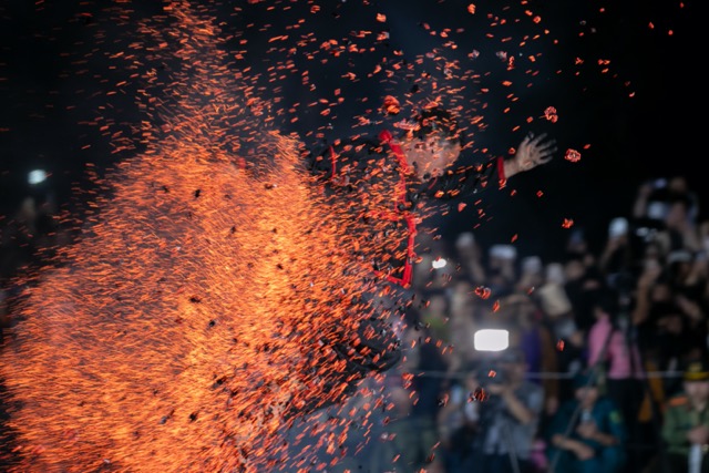 Nghệ nhân nhảy lửa chạy xuyên đống than, tro nóng rực. Ảnh: Minh Dân